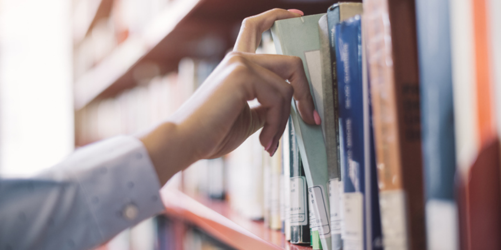 Patron selecting a book from the shelves