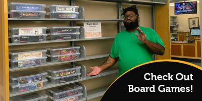Man gesturing towards board games on shelves