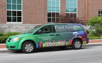 Green and Blue Youth Services Van parked in front of the Library
